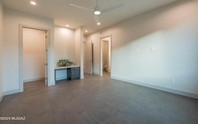 unfurnished room featuring ceiling fan and built in desk