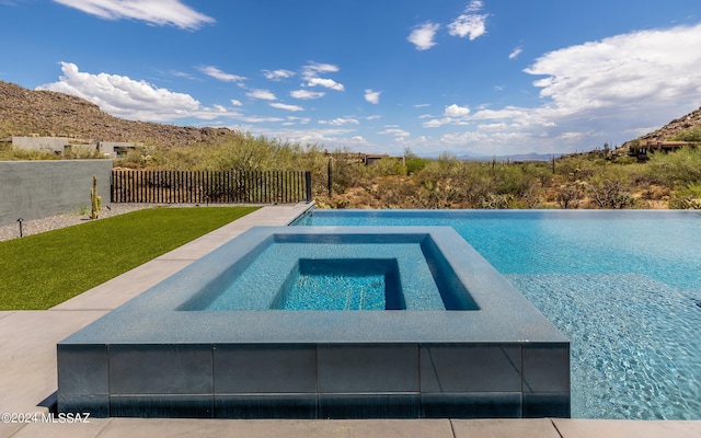 view of swimming pool with an in ground hot tub and a lawn