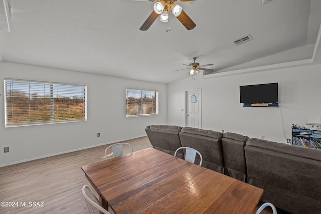 dining room featuring light hardwood / wood-style floors, vaulted ceiling, and ceiling fan