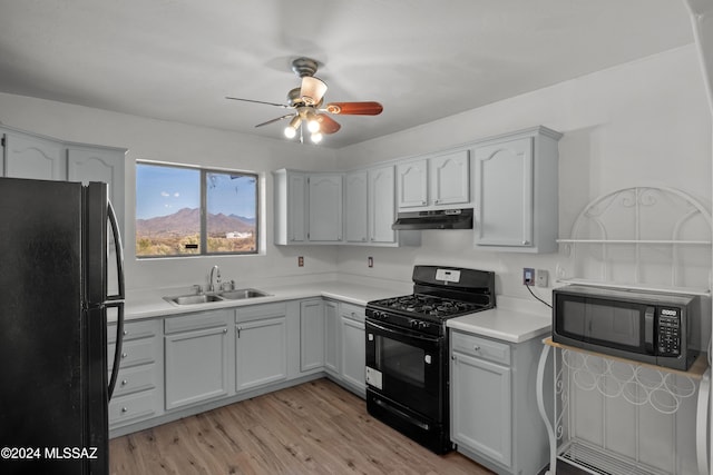 kitchen with sink, light hardwood / wood-style floors, ceiling fan, and black appliances