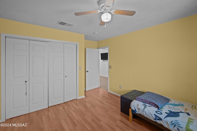 bedroom with ceiling fan, a closet, and light hardwood / wood-style flooring