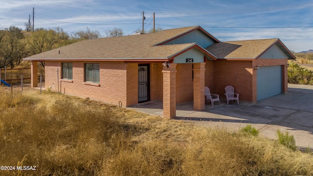 ranch-style home with a garage and a patio area