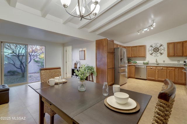 dining room with a notable chandelier, lofted ceiling with beams, light tile patterned floors, and sink