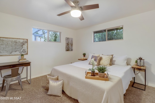 carpeted bedroom featuring multiple windows and ceiling fan