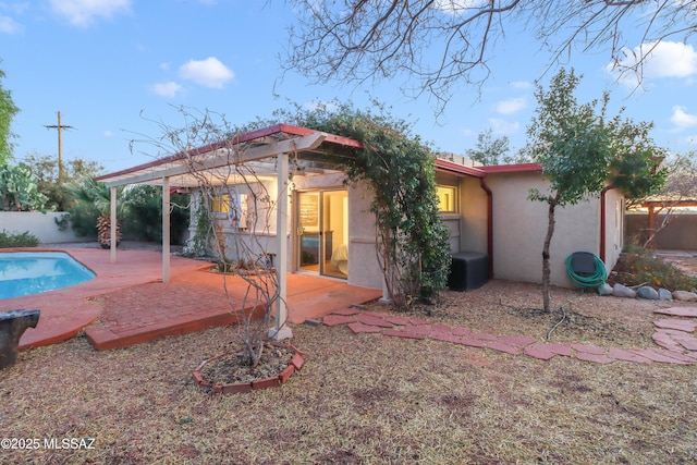 back of house featuring a fenced in pool and a patio