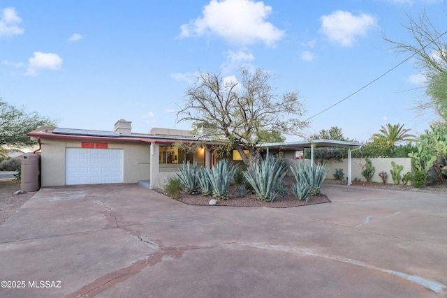 single story home with solar panels and a garage