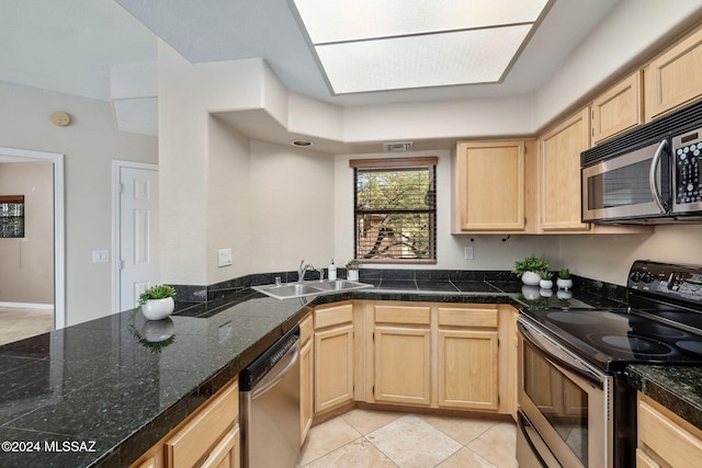 kitchen with sink, light tile patterned floors, stainless steel appliances, and light brown cabinetry