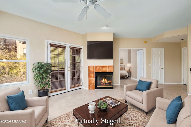 tiled living room with ceiling fan and a tiled fireplace