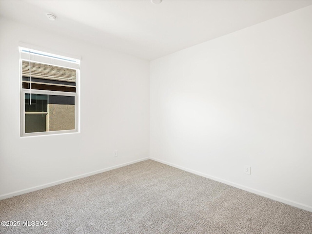 unfurnished room featuring carpet flooring and baseboards