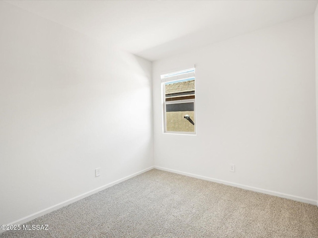 carpeted spare room with baseboards