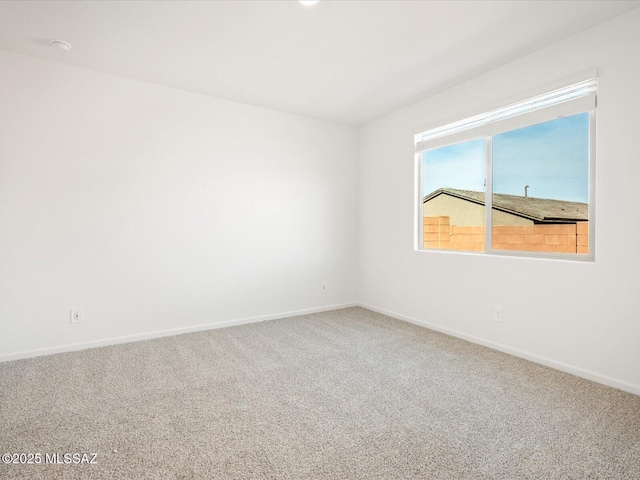 unfurnished room with carpet and baseboards