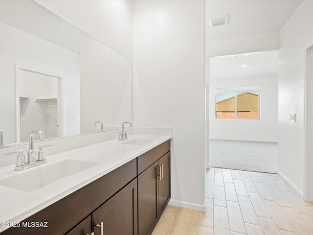 full bath with visible vents, a sink, baseboards, and double vanity