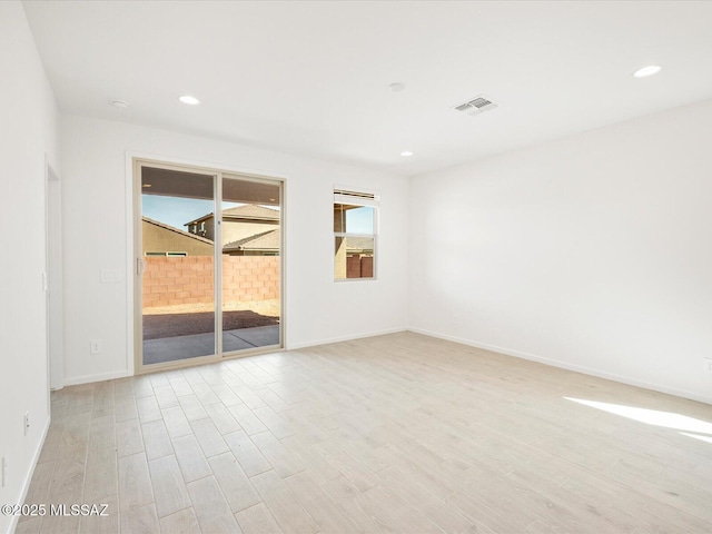 spare room with recessed lighting, visible vents, light wood-style flooring, and baseboards