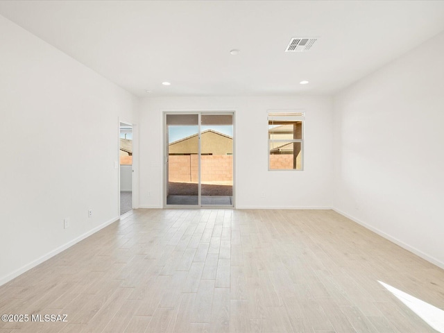 spare room with light wood-type flooring, visible vents, baseboards, and recessed lighting