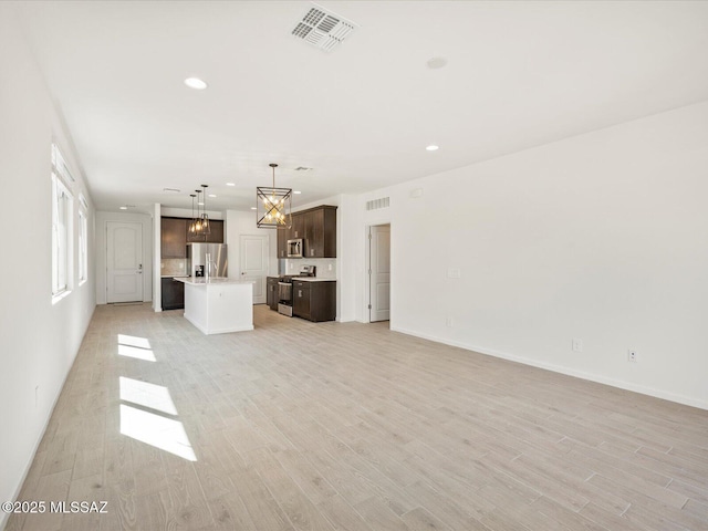 unfurnished living room with light wood-style flooring, visible vents, baseboards, and recessed lighting