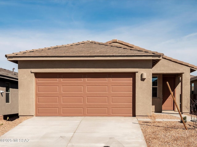 view of front facade featuring a garage, concrete driveway, and stucco siding