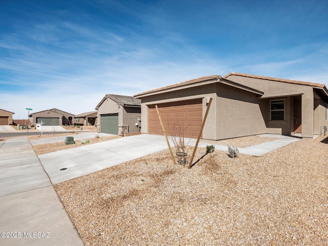 view of front of home featuring concrete driveway, an attached garage, and stucco siding