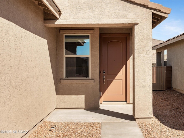 view of exterior entry with stucco siding