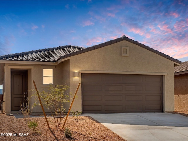 view of front of property featuring a garage, driveway, and stucco siding