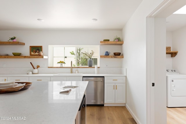 kitchen featuring a sink, white cabinets, stainless steel dishwasher, open shelves, and washer / clothes dryer