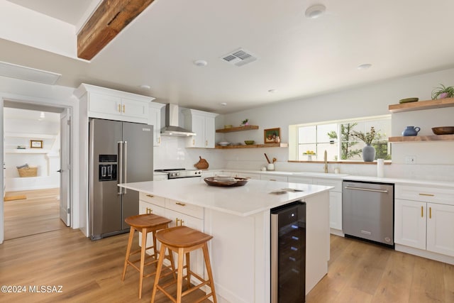 kitchen with white cabinets, sink, beverage cooler, and stainless steel appliances