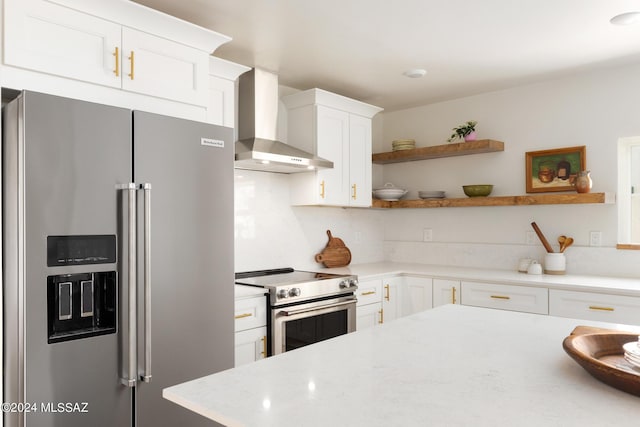 kitchen with stainless steel appliances, open shelves, white cabinets, light stone countertops, and wall chimney exhaust hood