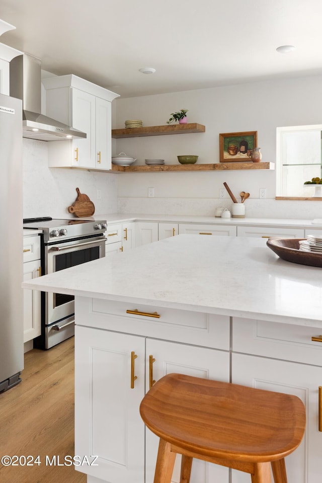 kitchen with light wood-style flooring, white cabinetry, freestanding refrigerator, stainless steel electric range oven, and open shelves