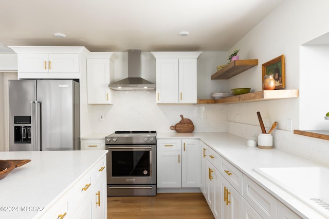 kitchen featuring open shelves, stainless steel appliances, light countertops, white cabinetry, and wall chimney exhaust hood