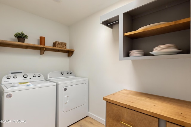 laundry room with baseboards, laundry area, washing machine and dryer, and light wood-style floors