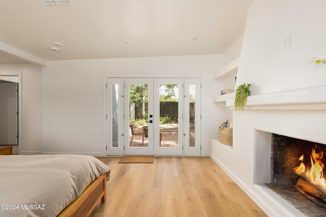 bedroom with access to exterior, light hardwood / wood-style flooring, and french doors