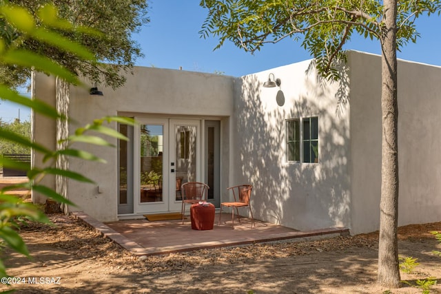 doorway to property featuring stucco siding and french doors