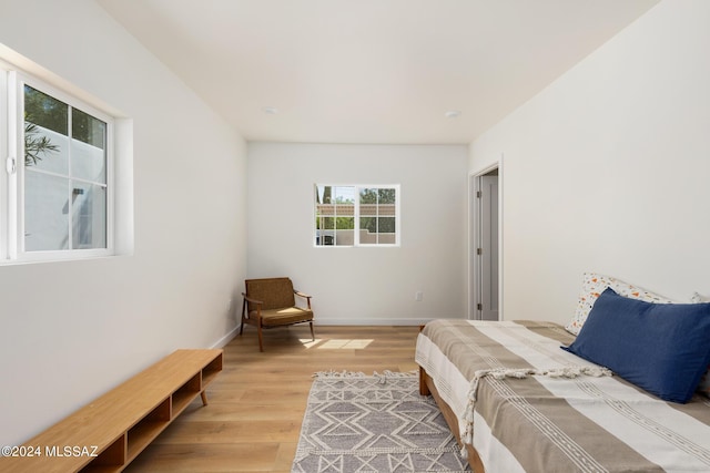 bedroom featuring light wood finished floors and baseboards