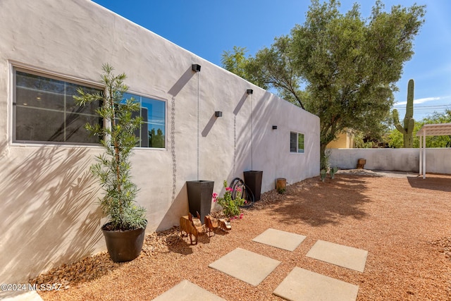 view of property exterior with fence and stucco siding