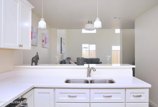 kitchen with white cabinets, hanging light fixtures, and sink