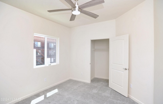 unfurnished bedroom featuring ceiling fan, a closet, and light colored carpet