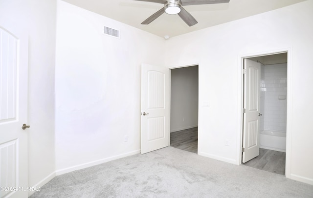 unfurnished bedroom with light carpet, ensuite bathroom, and ceiling fan