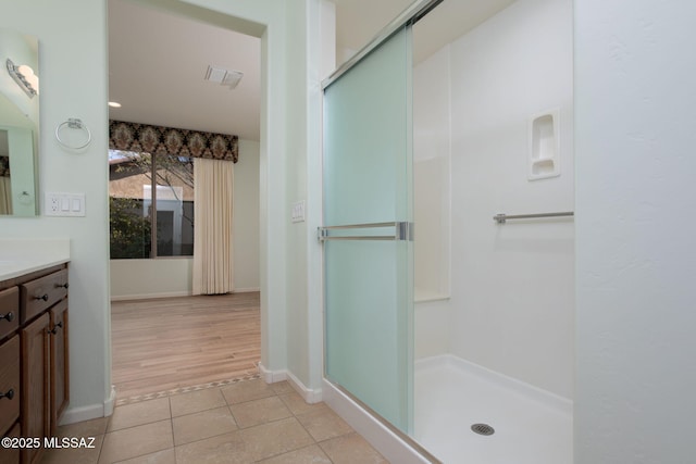 bathroom with tile patterned floors, vanity, and walk in shower