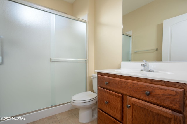 bathroom featuring tile patterned flooring, vanity, toilet, and a shower with door