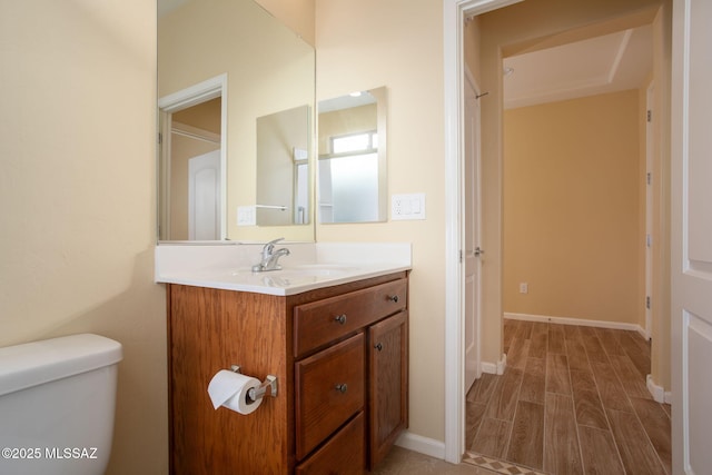 bathroom with wood-type flooring, vanity, and toilet