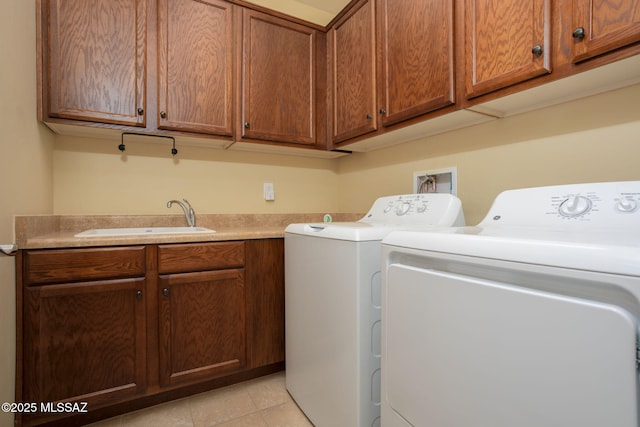 washroom with washing machine and clothes dryer, cabinets, and sink