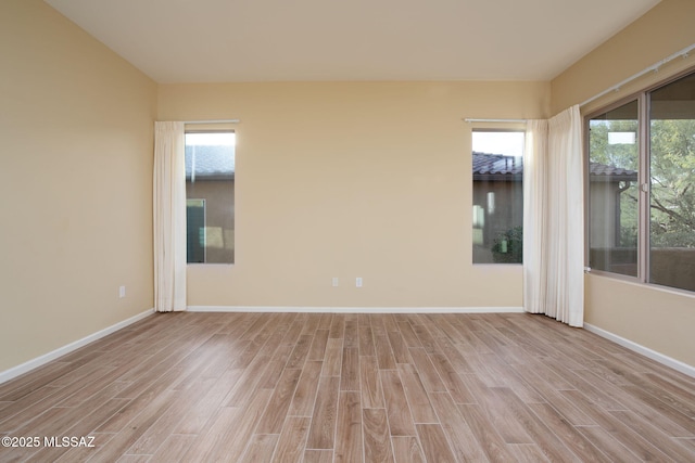 empty room featuring plenty of natural light and light hardwood / wood-style floors