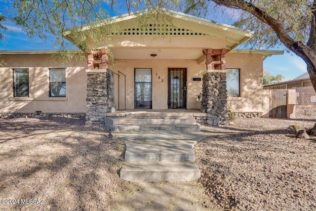 view of front of house with stucco siding and a porch