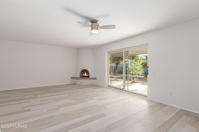 unfurnished living room with a fireplace, light hardwood / wood-style flooring, and ceiling fan