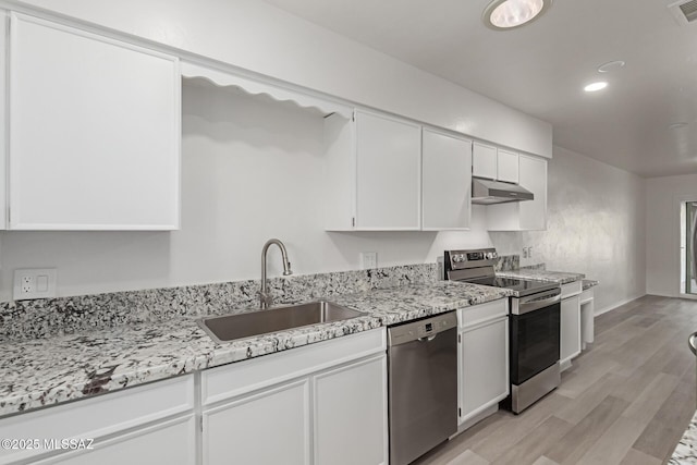 kitchen with white cabinetry, sink, stainless steel appliances, light stone counters, and light hardwood / wood-style flooring