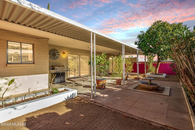 patio terrace at dusk featuring grilling area