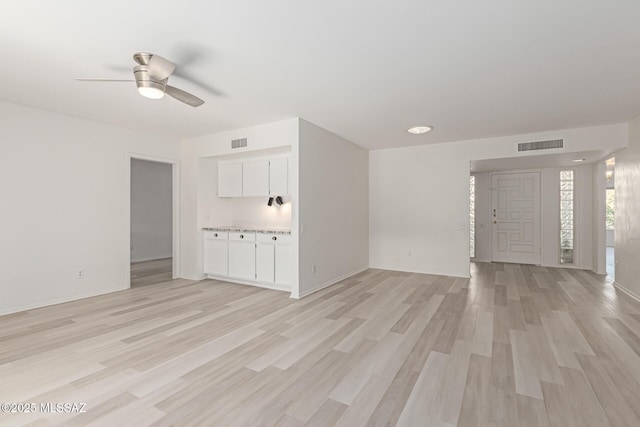 unfurnished living room with ceiling fan and light hardwood / wood-style floors