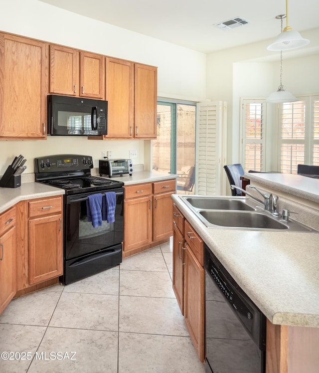 kitchen with sink, decorative light fixtures, a wealth of natural light, and black appliances