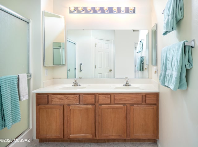 bathroom with tile patterned flooring, vanity, and walk in shower