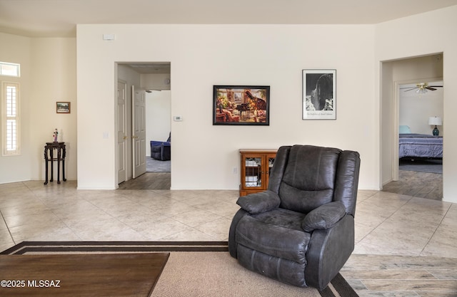 living area featuring ceiling fan and light tile patterned flooring