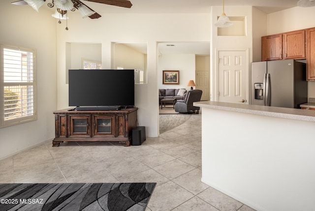 kitchen featuring stainless steel fridge with ice dispenser, light tile patterned floors, and pendant lighting